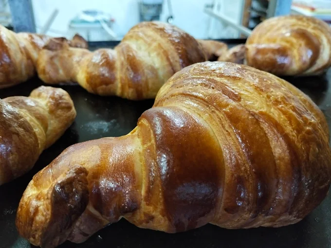Croissants artesanales dorados recién hechos en la pastelería