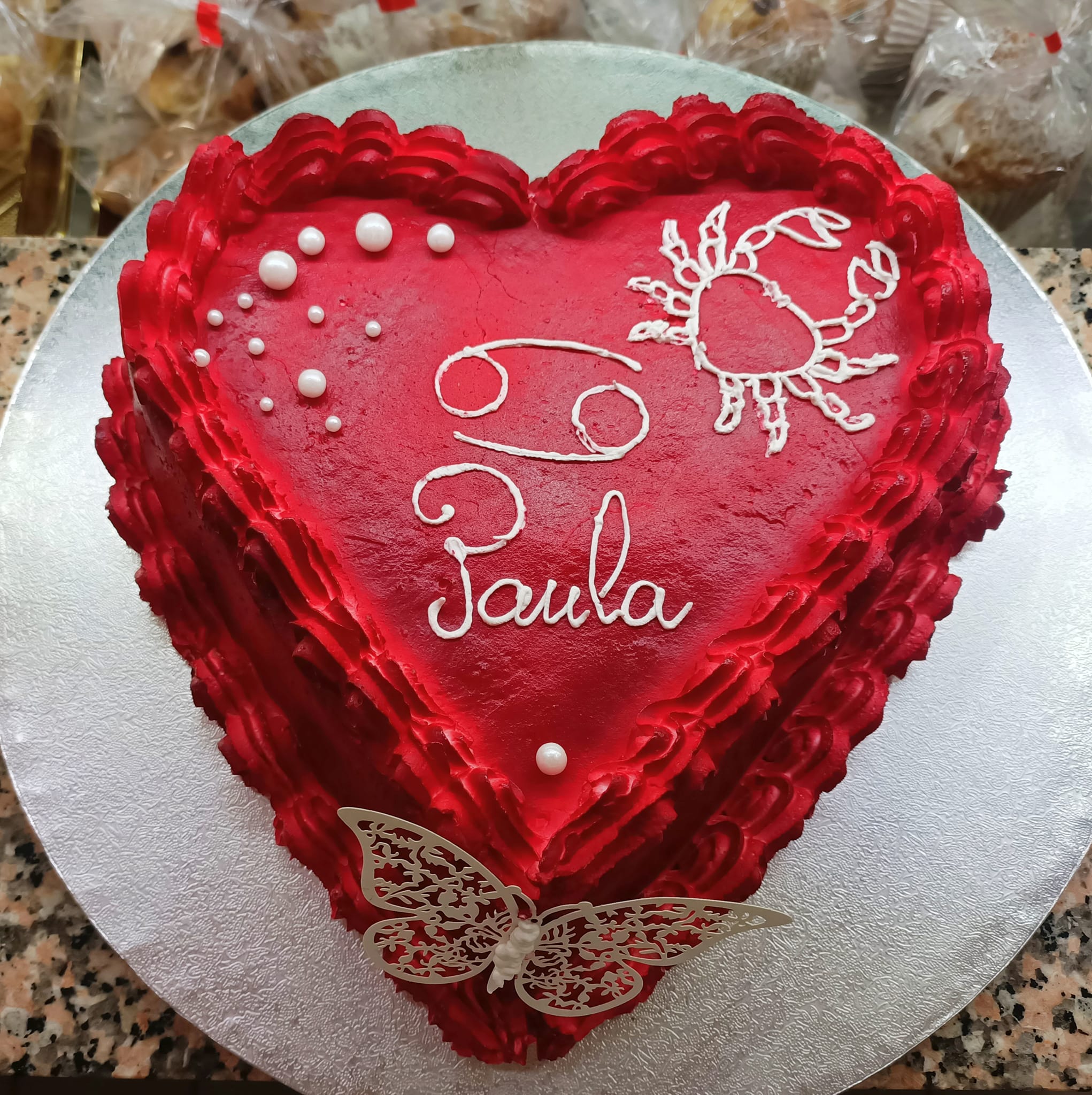 Tarta personalizada en forma de corazón Tarta artesana personalizada en forma de corazón, decorada en rojo con el nombre escrito a mano.